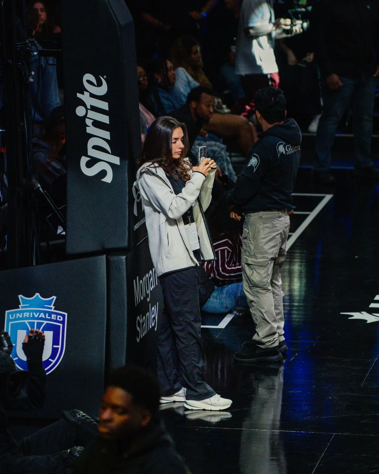 Camilla Flefil filming courtside at Unrivaled Basketball with Sprite signage visible